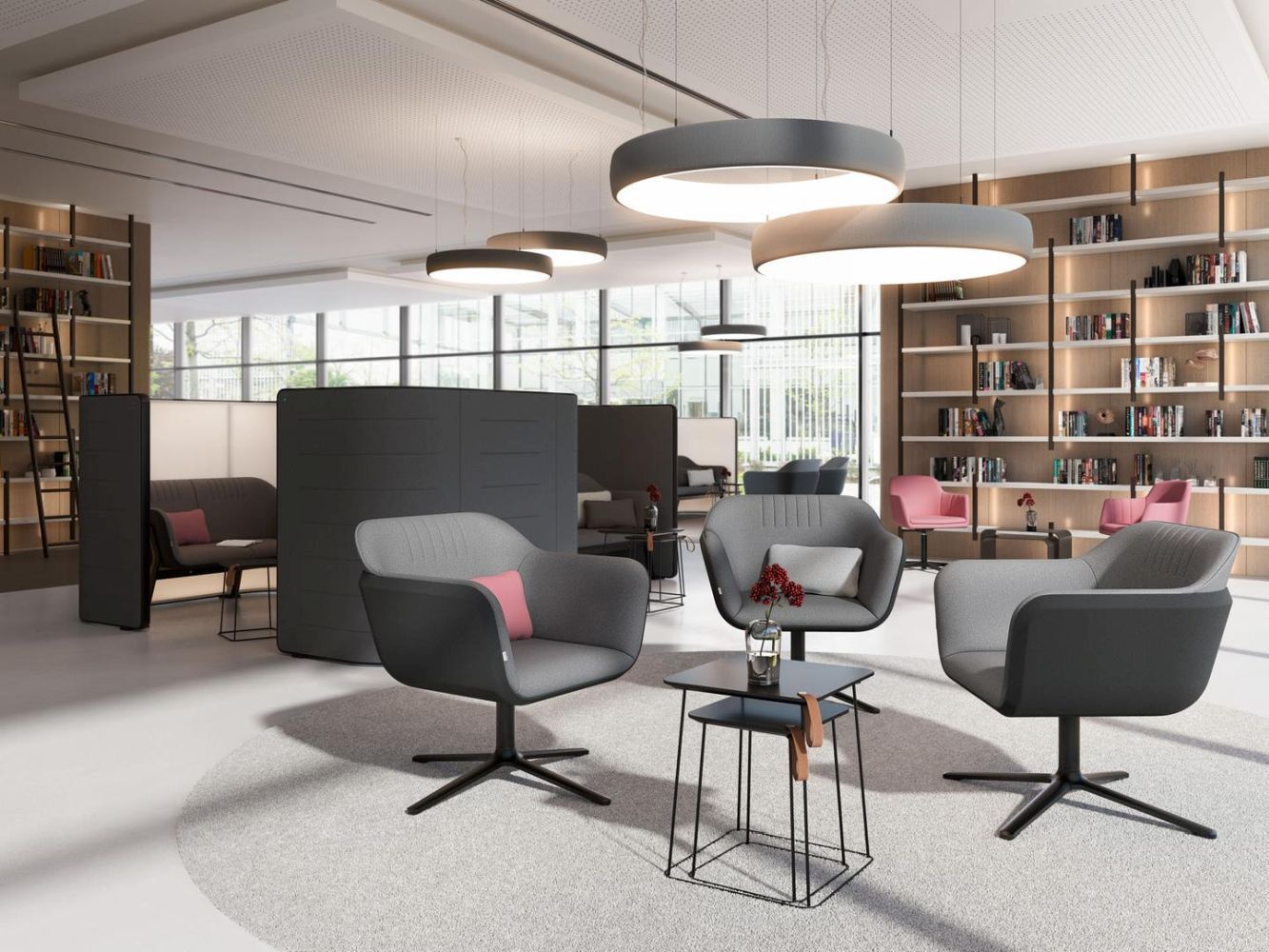 Moderne Lounge mit grauen ergonomischen Sitzstühlen, runder Tisch, Bücherregale im Hintergrund, hell beleuchtet.