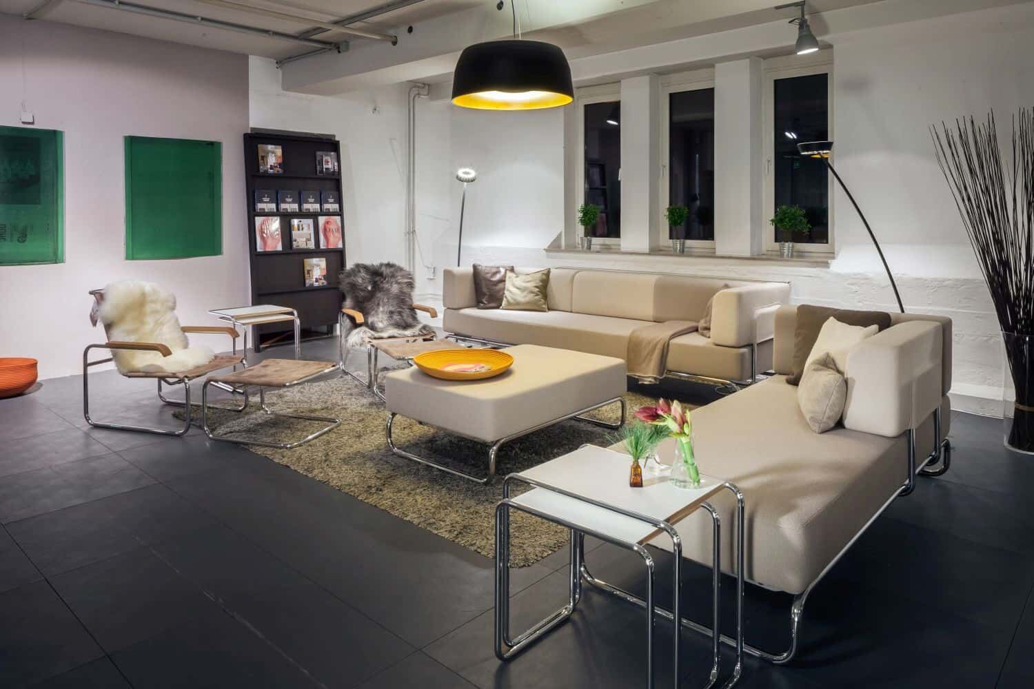 Elegante Lounge mit hellen Sofas und Sesseln auf einem Teppich, umgeben von modernen Dekorationen.