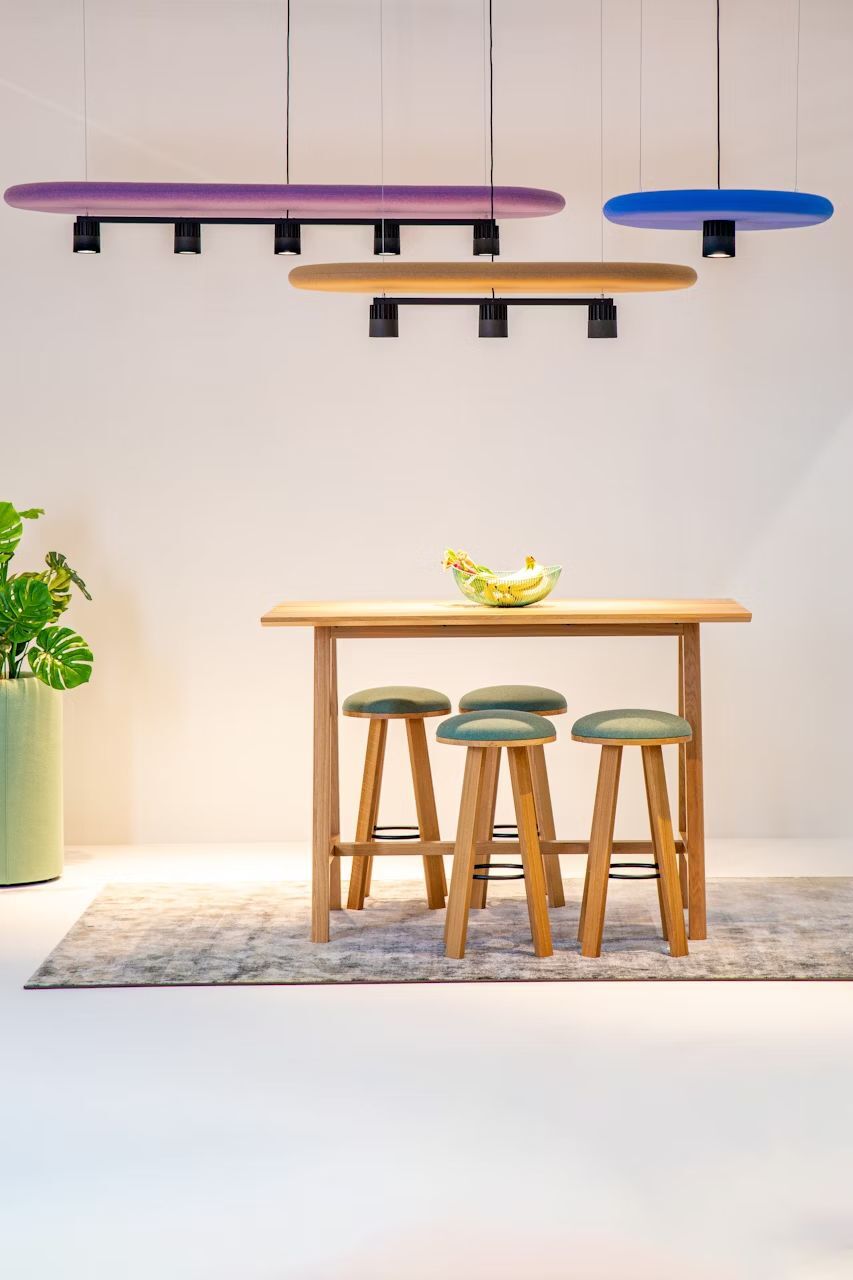 Moderner Essbereich mit Hochtisch, drei Hockern und stilvollen Hängelampen in bunten Farben.