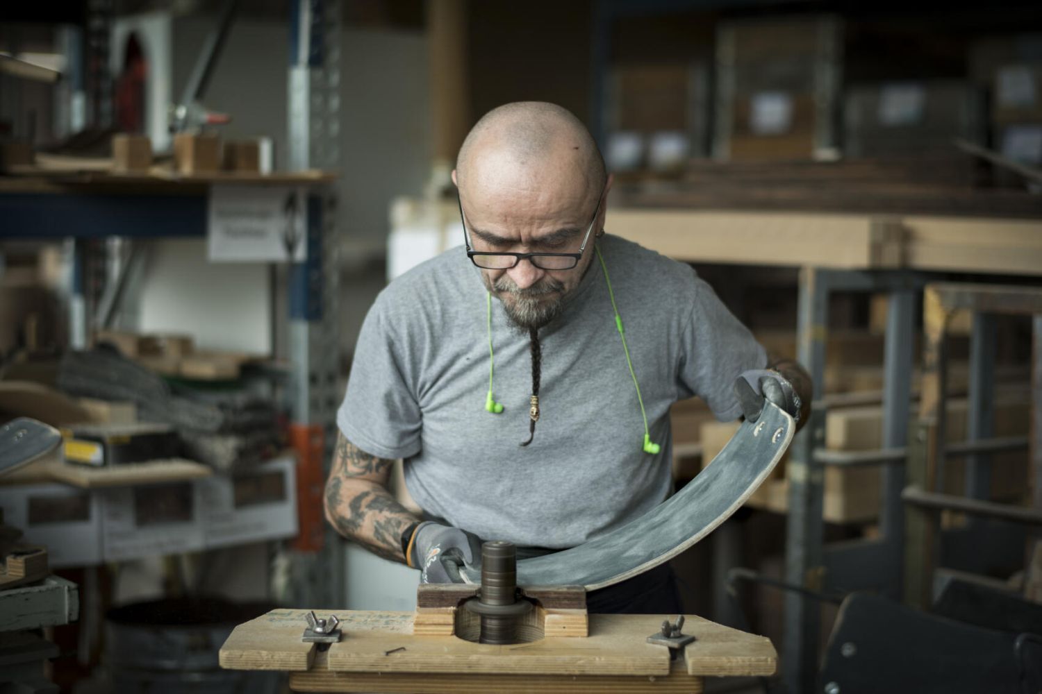 Handwerker bearbeitet ein Stuhllehne, um Ergonomie und Qualität zu gewährleisten, in einer Werkstattumgebung.