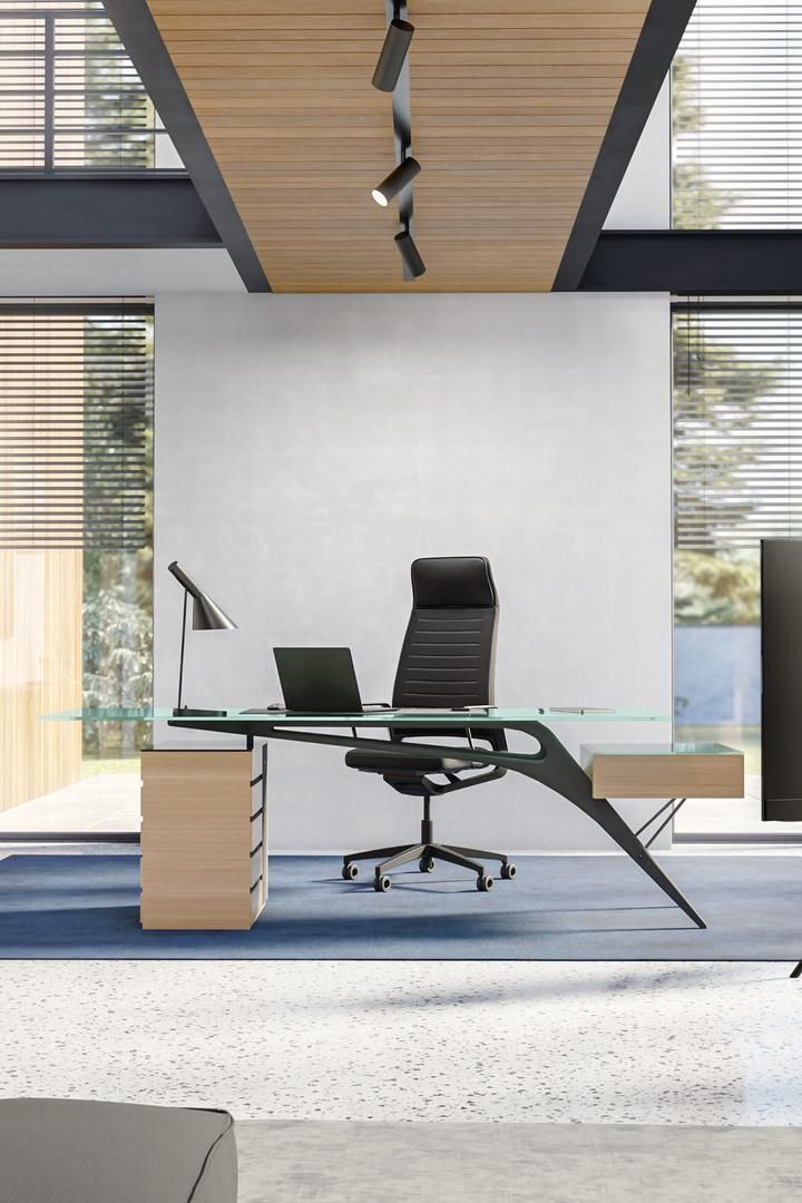 Modernes Büro mit ergonomischem Stuhl, Glastisch und Laptop, ideal für produktives Arbeiten und Wohlbefinden.