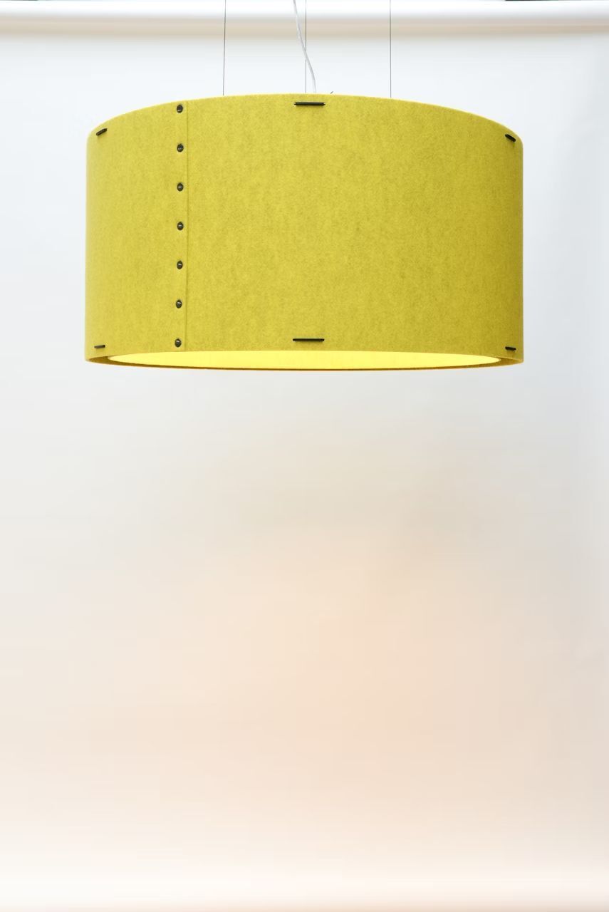 Hängelampe mit gelbem Lampenschirm vor neutralem Hintergrund, minimalistisches Design.