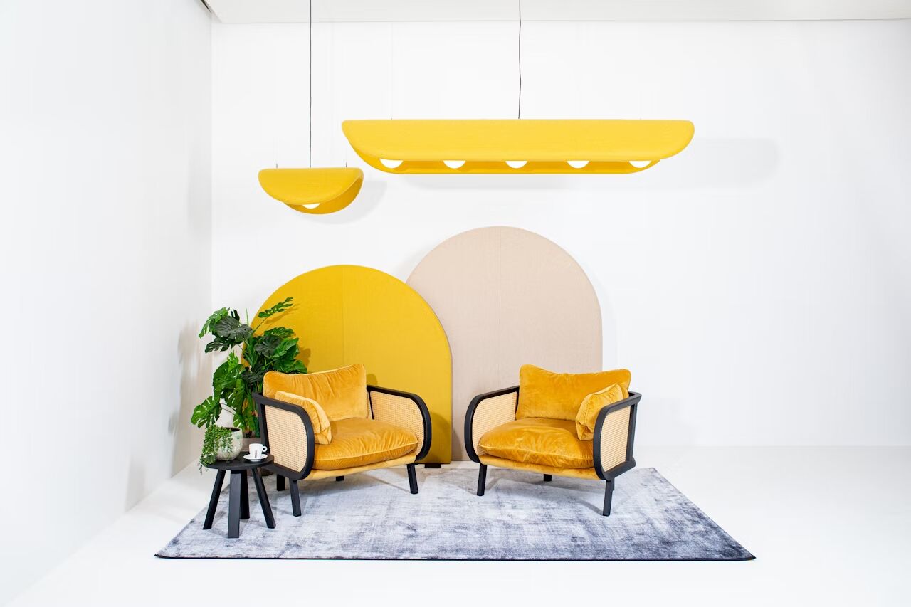 Moderne Wohnzimmer-Einrichtung mit gelben Sesseln, Pflanzen und minimalistischen Leuchten auf hellem Hintergrund.