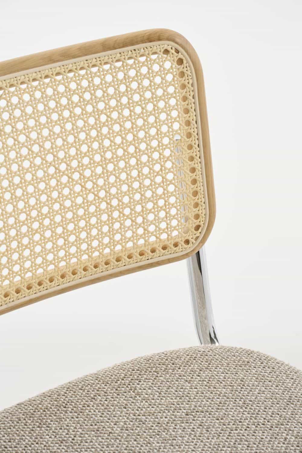 Detailaufnahme eines ergonomischen Stuhls mit geflochtener Rückenlehne und gepolsterter Sitzfläche aus beigem Stoff.