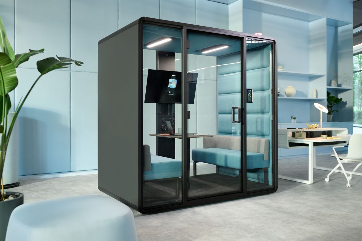 Moderne Bürokabine mit Glaswänden, ausgestattet mit Sofa und Monitor, in einem stilvollen, ergonomischen Büro.