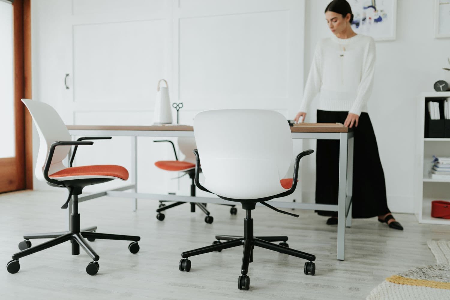 Moderner ergonomischer Bürostuhl mit weißem Rücken und rotem Sitz, ideal für dynamisches Sitzen.