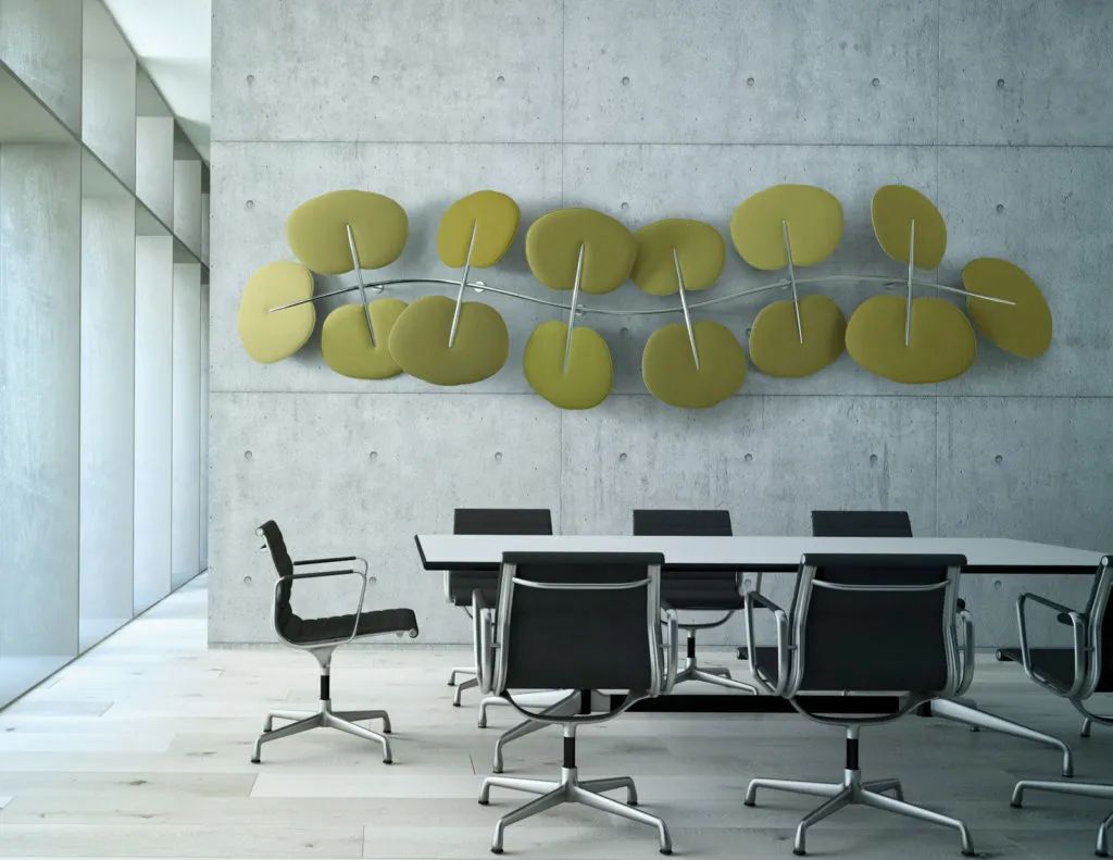 Moderner Konferenzraum mit ergonomischen Bürostühlen und abstraktem Kunstwerk an Betonwand.