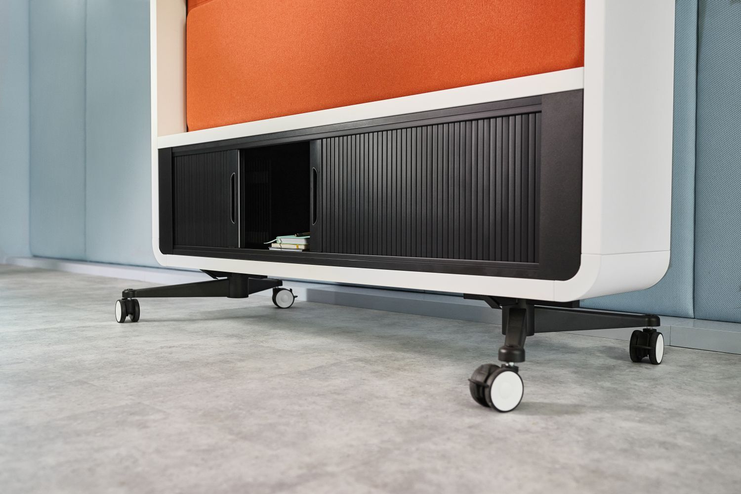 Ergonomischer Büroschrank auf Rollen mit schwarzem Stauraum und orangefarbener Ablage in modernem Büro.