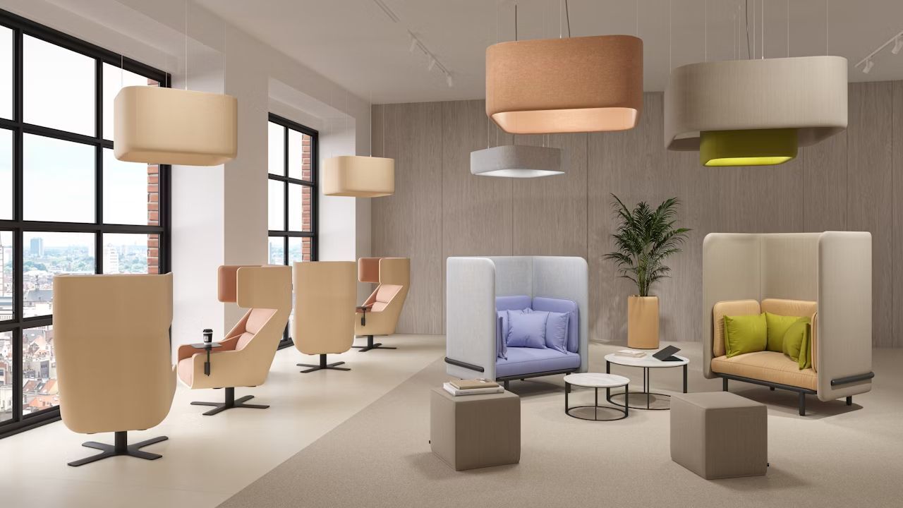 Ergonomische Sitzgruppe mit hellen Sesseln, modernen Leuchten und Tisch in einem eleganten Büroraum mit großem Fenster.