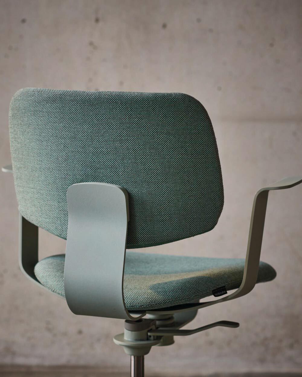 Eleganter, grüner ergonomischer Bürostuhl mit metallischen Armlehnen, ideal für gesundes Sitzen im Büro.