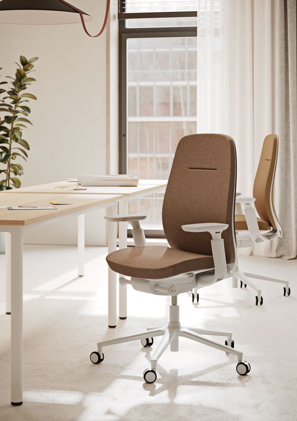 Büro mit ergonomischen Stühlen auf Rollen, hellem Arbeitsplatz und großen Fenstern im Hintergrund.