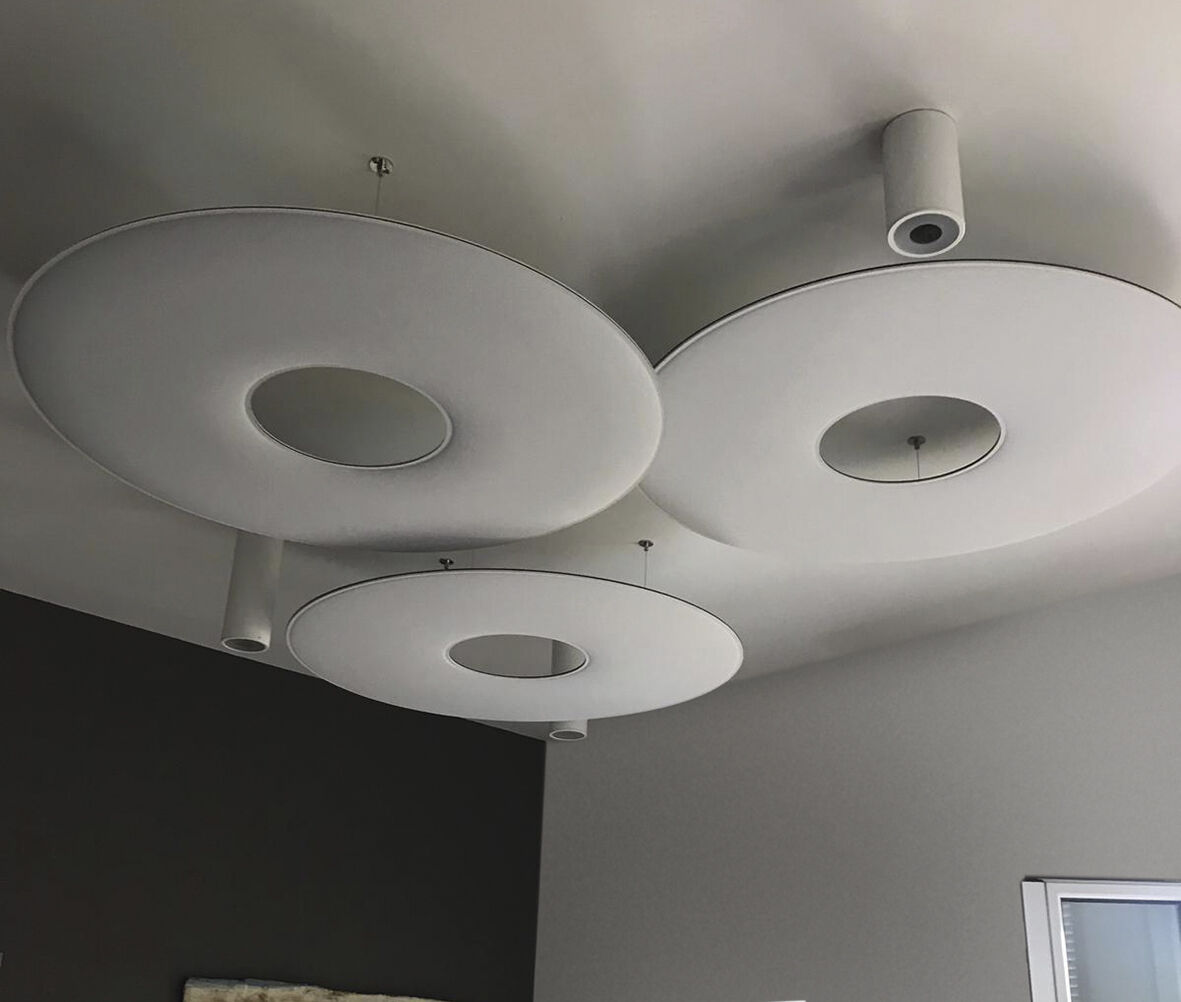 Runde, moderne Deckenleuchten in sanftem Weißton, stilvoll und minimalistisch gestaltet, an einer grauen Decke.