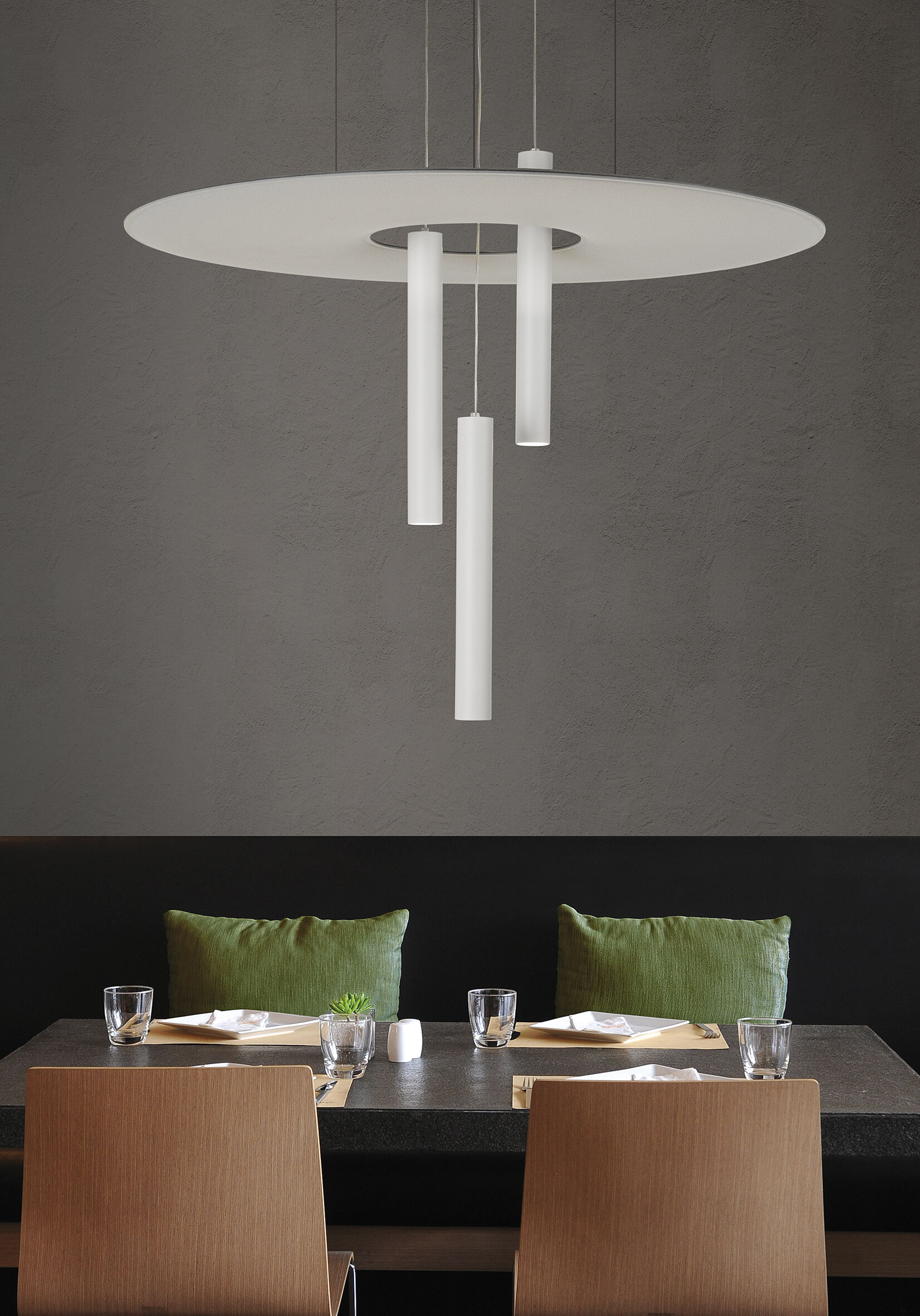 Moderner Esstisch mit grünen Kissen, stilvoll gedeckt, unter einer Designer-Pendelleuchte in elegantem Ambiente.