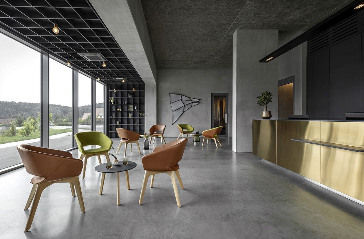 Moderne Wartebereich mit ergonomischen Stühlen, großen Fenstern und stilvollem Tresen in einem eleganten Raum.