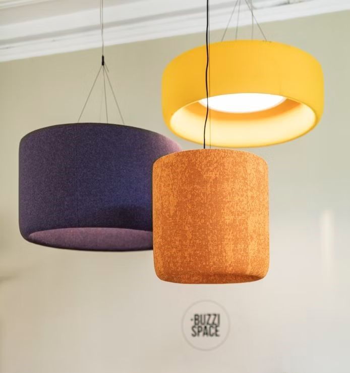 Drei moderne Hängelampen in Gelb, Orange und Lila, im minimalistischen Design, beleuchten den Raum stilvoll.