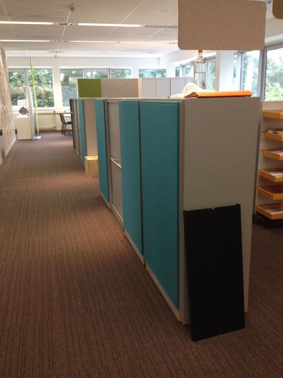 Büro mit ergonomischen Möbeln, Trennwänden und natürlichem Licht, fördert aktives und gesundes Arbeiten.
