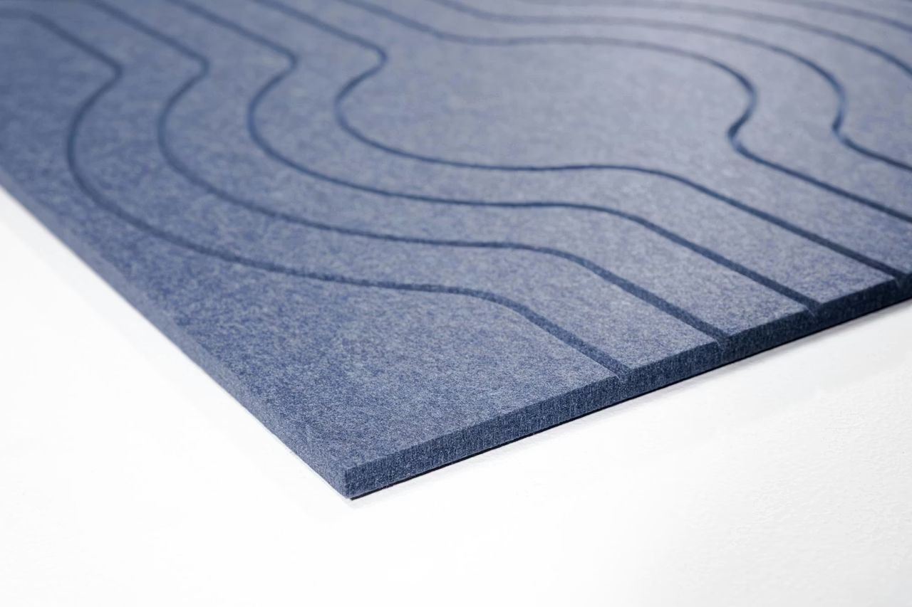 Nahaufnahme einer blauen, strukturierten Büromatte mit wellenförmigen Rillen für ergonomisches Arbeiten.