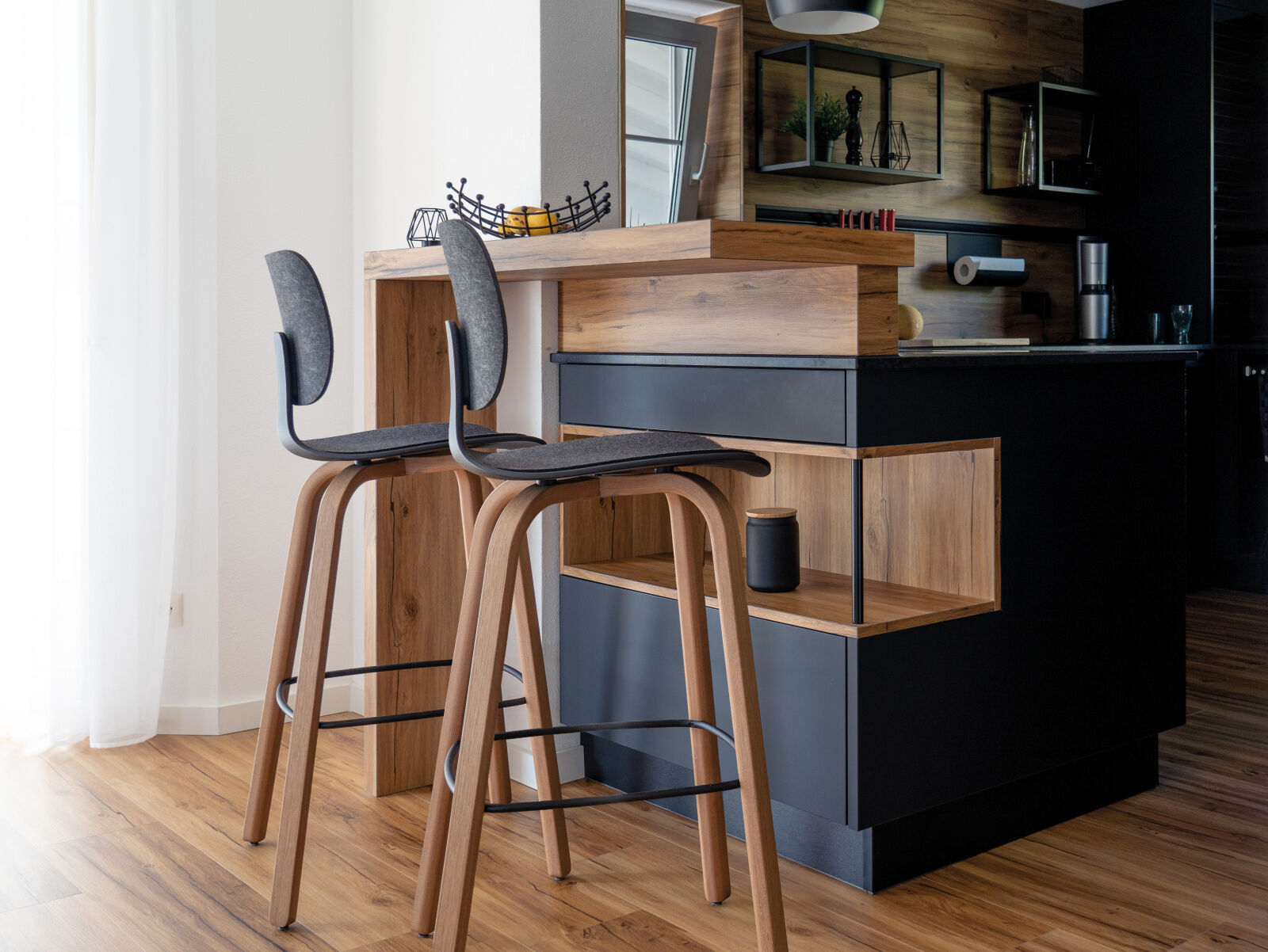 Moderne Küche mit zwei hohen Holzstühlen an einer Theke aus Holz, minimalistisches und elegantes Design.