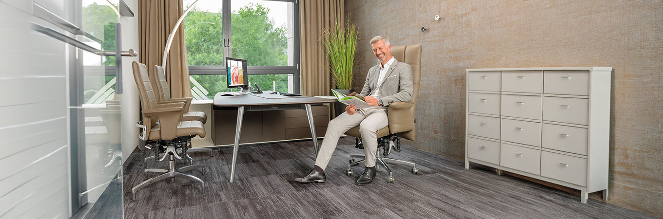 Mann sitzt auf einem Haider Bioswing 780iQ Bürostuhl mit Leder