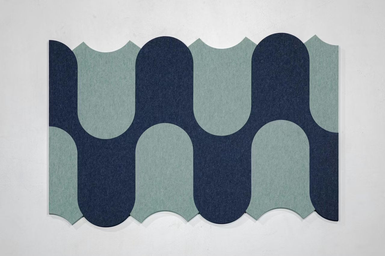Geometrisches Wandpaneel in Grau und Blau, bestehend aus wellenförmigen Mustern und geschwungenen Formen.