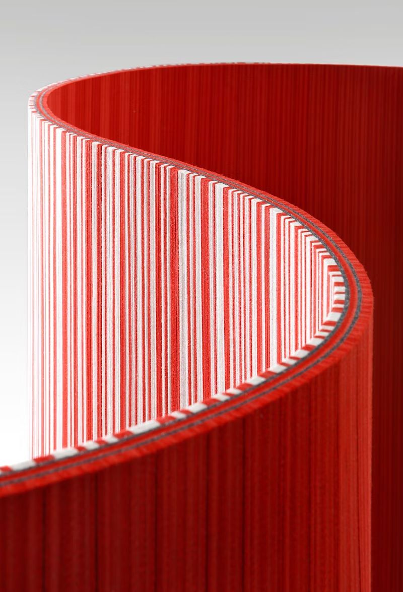 Nahaufnahme eines rot-weiß gestreiften, geschwungenen Bürotrennwand-Designs, das Dynamik im Raum bietet.