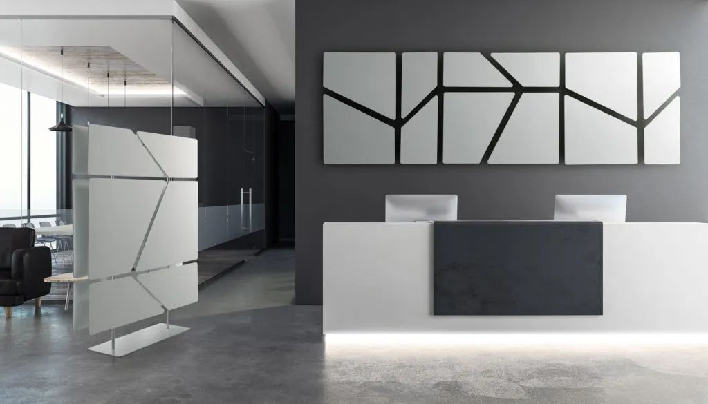 Moderner heller Empfangsbereich mit graphischen Wanddekorationen und elegantem, minimalistischem Schreibtisch in einem Büro.