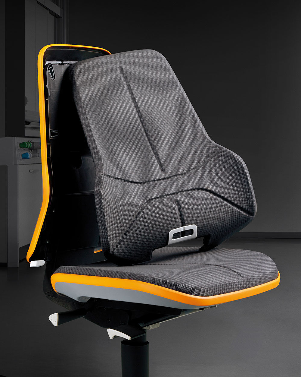 Ergonomischer Bürostuhl mit schwarzem Polster und auffälligen orangenen Akzenten, betont dynamisches Sitzen.