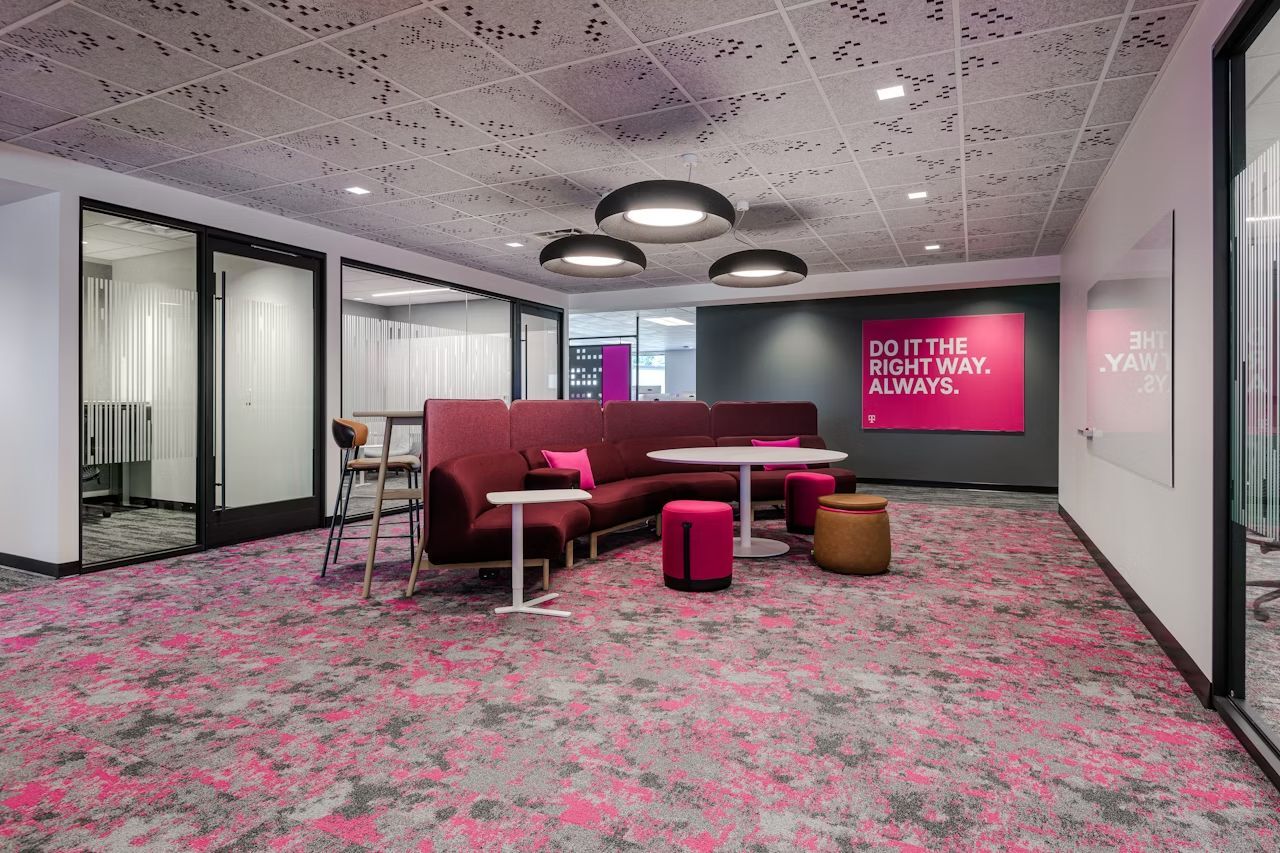 Modernes Büro mit ergonomischen Möbeln, rosa Teppich und leuchtendem „Do It The Right Way. Always.“-Schild.