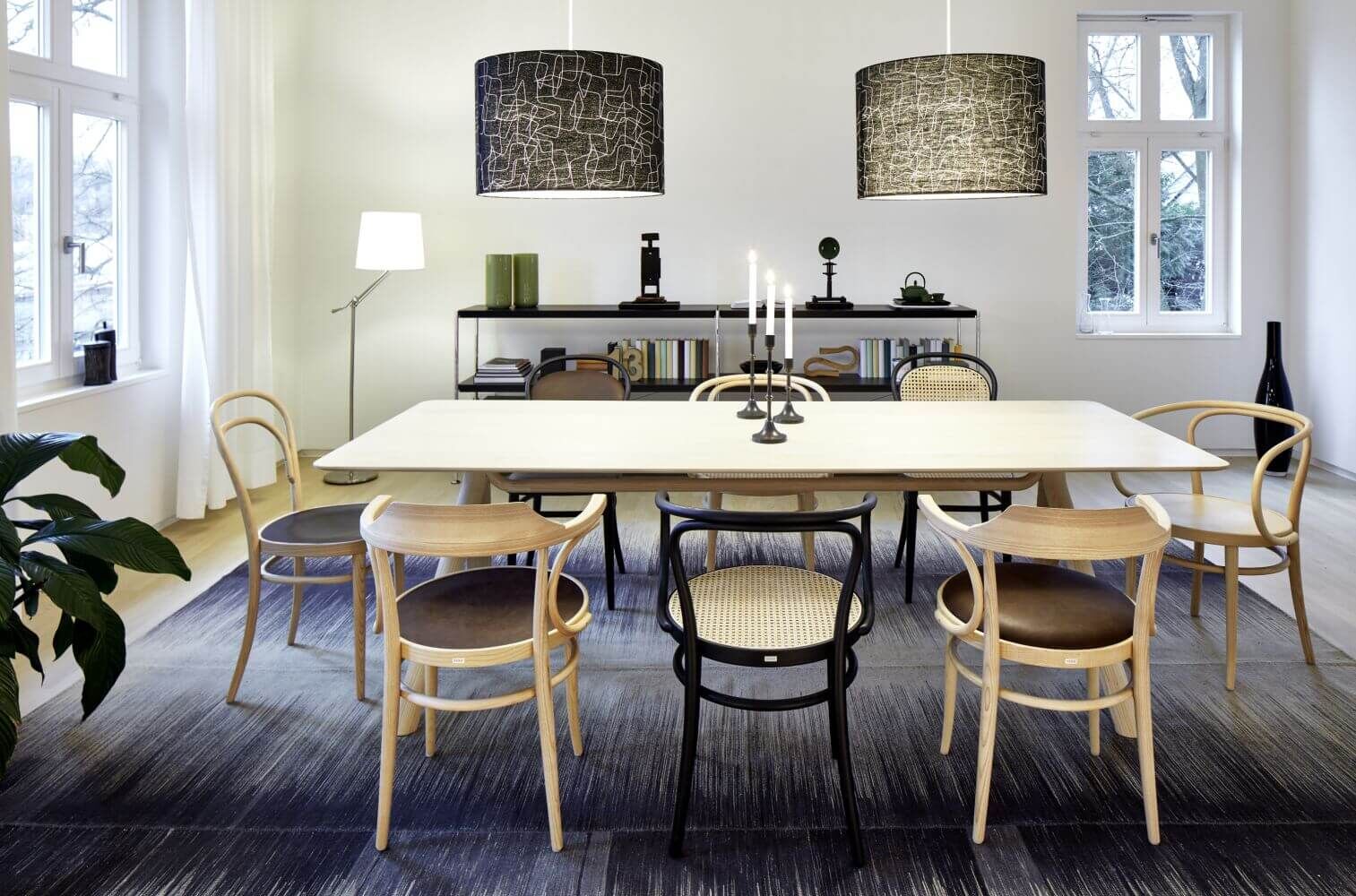 Moderner Essbereich mit braunen Holzmöbeln, großem Tisch und dekorativen Hängelampen, gestaltet für dynamisches Sitzen.