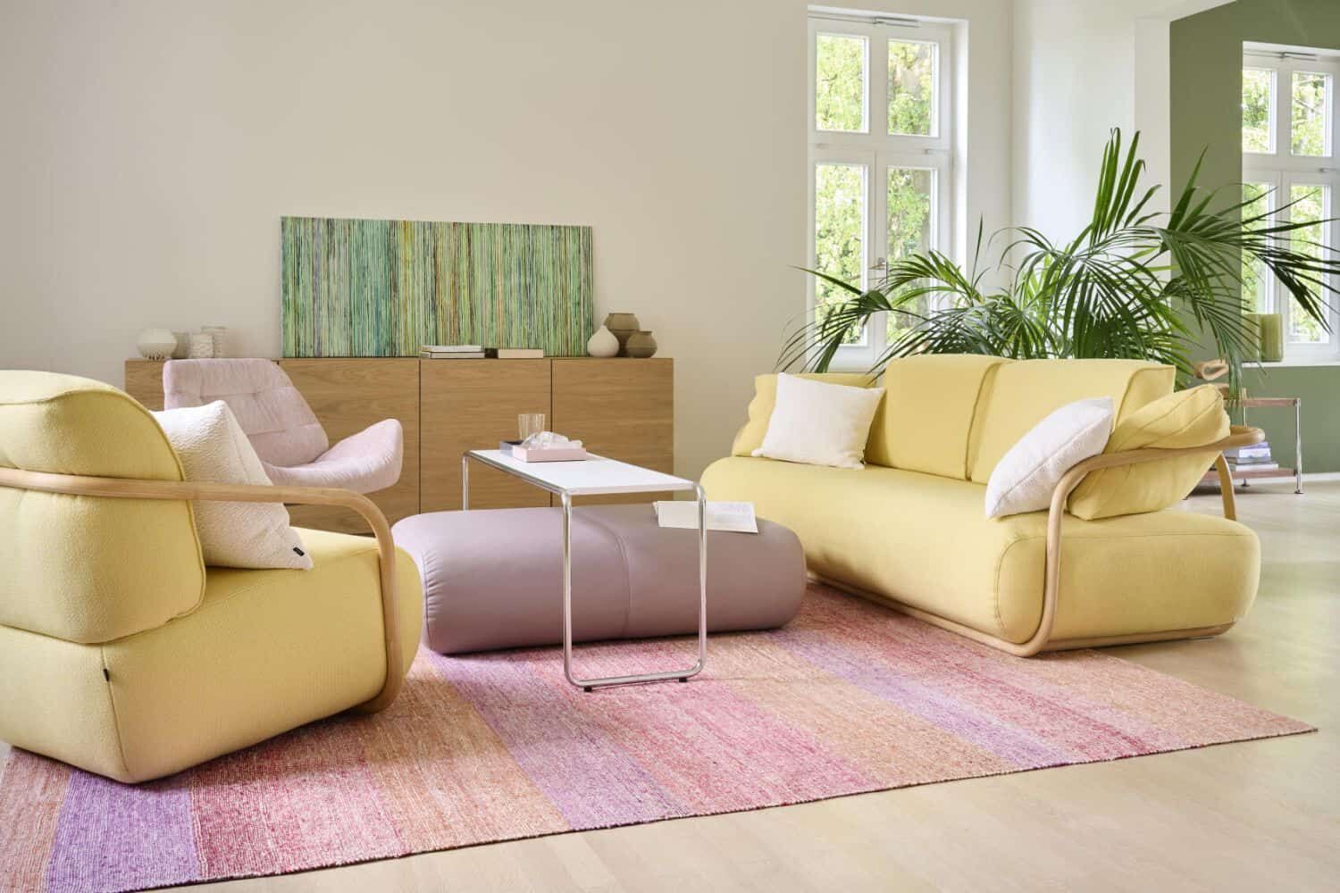 Modernes Wohnzimmer mit gelbem Sofa, Sesseln und hellem Dekor, ideal für eine entspannte, stylische Atmosphäre.