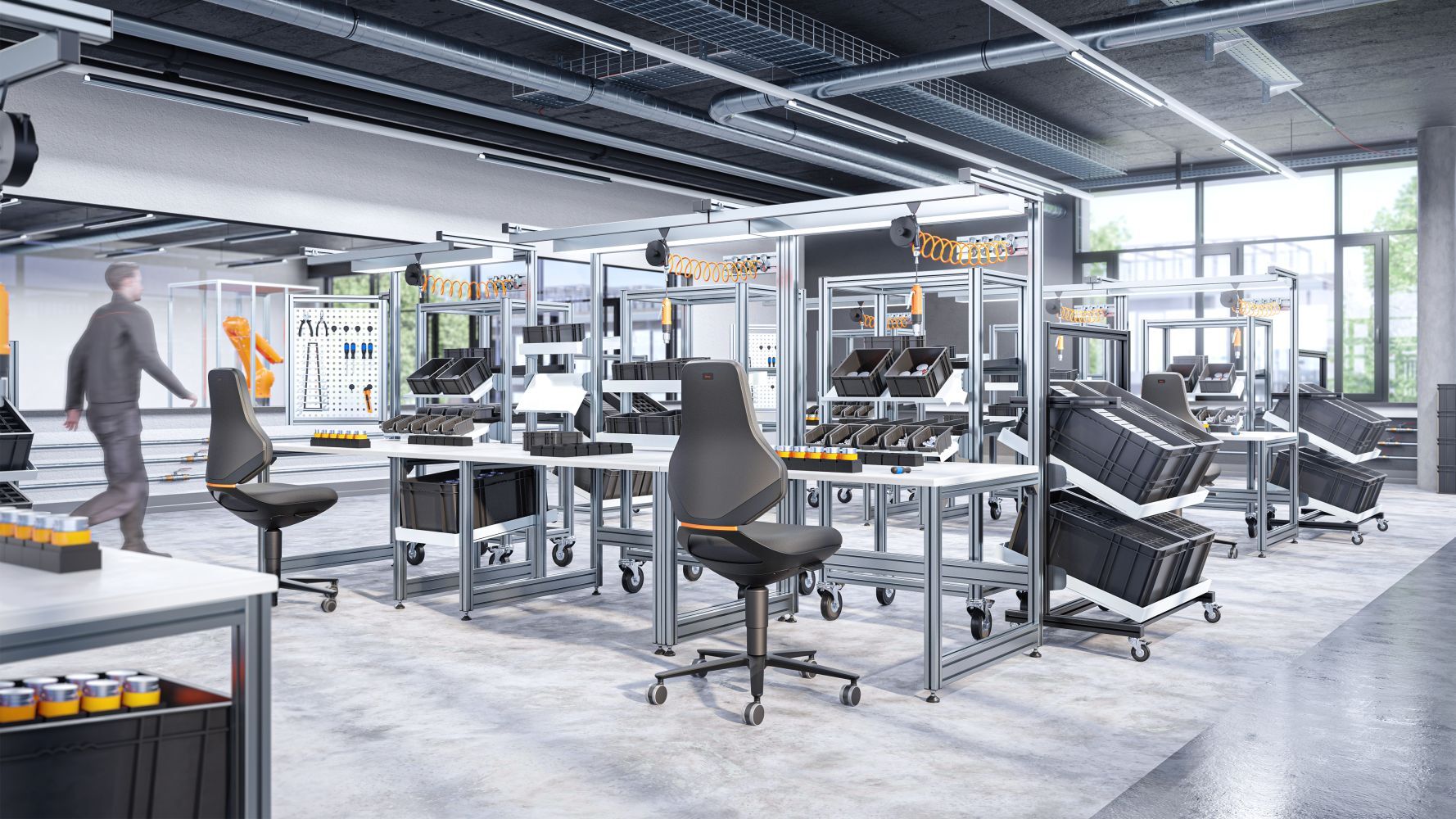 Moderne Werkstatt mit ergonomischen Bürostühlen, Montagetischen und Werkzeugen unter industrieller Beleuchtung.