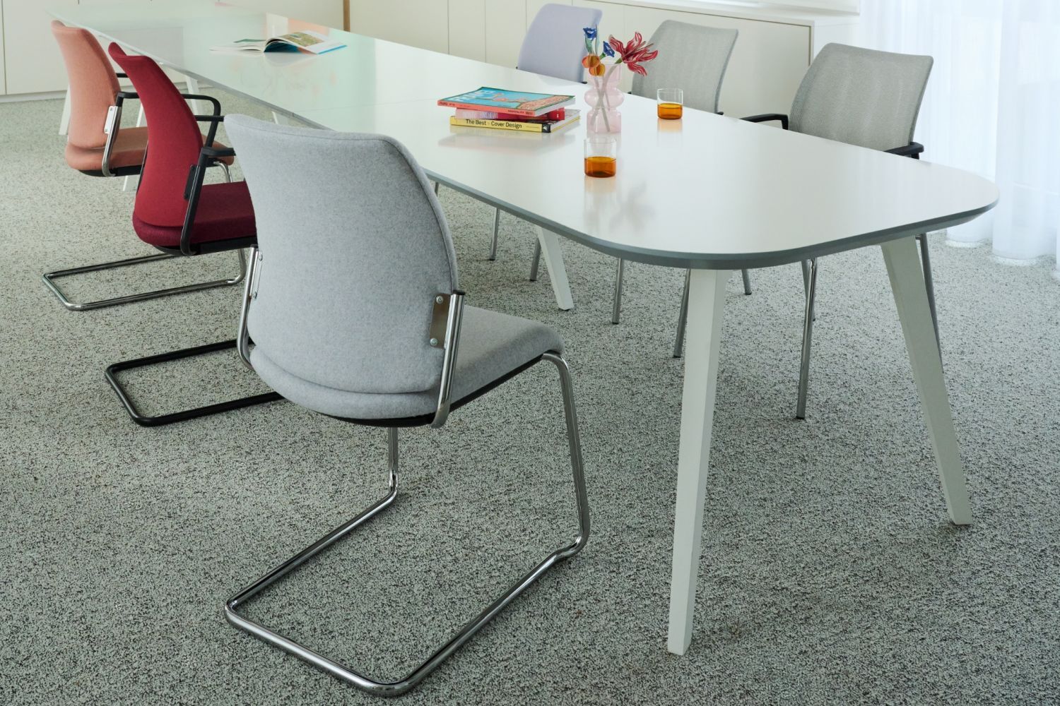 Ergonomische Schwingstühle um einen modernen weißen Tisch, ideal für dynamisches Sitzen im Büro oder Konferenzraum.