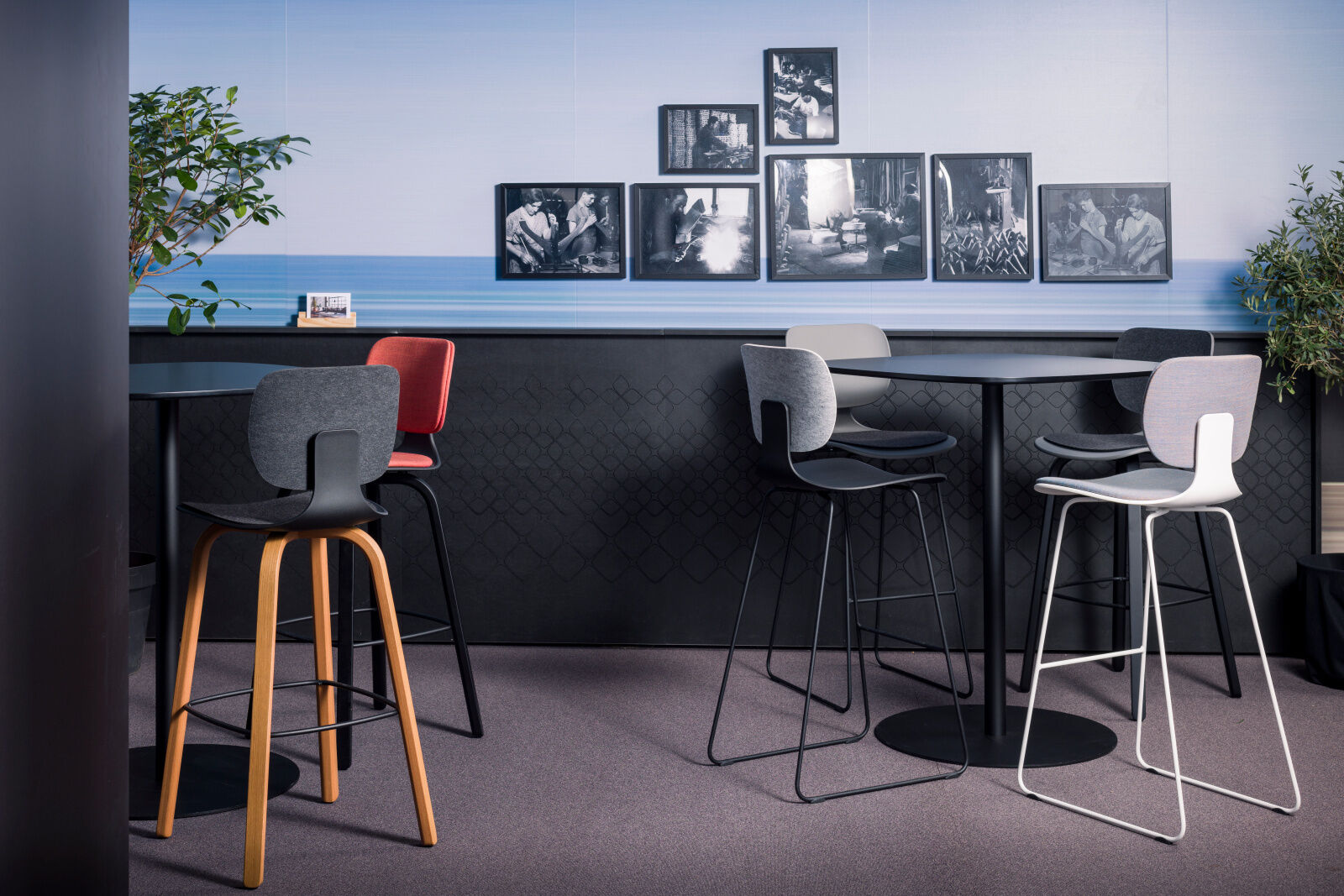 Moderne Hochstühle um Tische, dekoriert mit Schwarz-Weiß-Bildern an der Wand, in einem stilvollen Büroambiente.