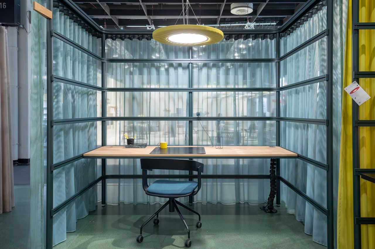 Ergonomischer Arbeitsplatz mit Schreibtisch, Bürostuhl und vielseitiger Beleuchtung für dynamisches Sitzen in modernem Umfeld.