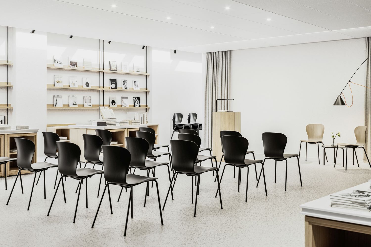 Moderner Seminarraum mit schwarzen ergonomischen Stühlen, Bücherregalen und stilvoller Beleuchtung, fördert dynamisches Sitzen.