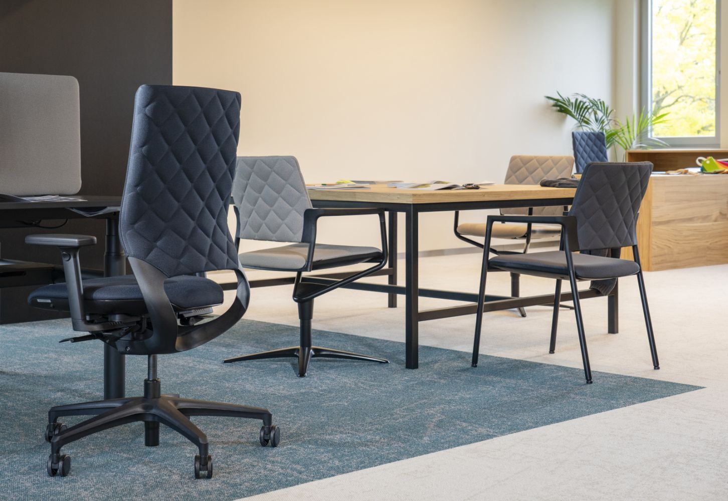 Elegantes Büro mit ergonomischen Bürostühlen und Holztisch, betont dynamisches Sitzen und gesundes Arbeitsumfeld.