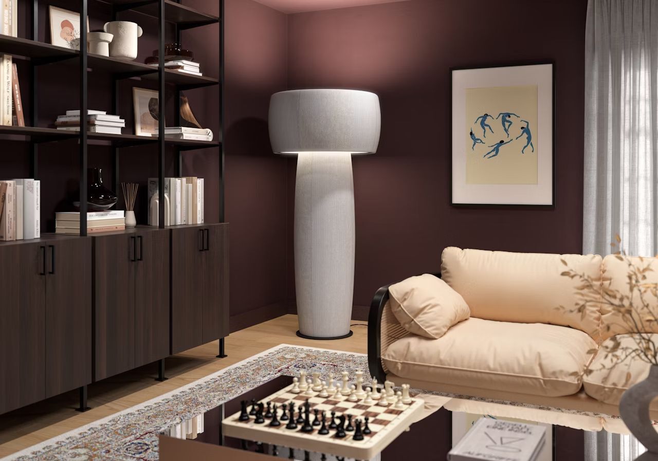 Elegantes Wohnzimmer mit beigefarbenem Sofa, hohe Stehlampe, Bücherregal und Schachbrett auf dem Tisch.