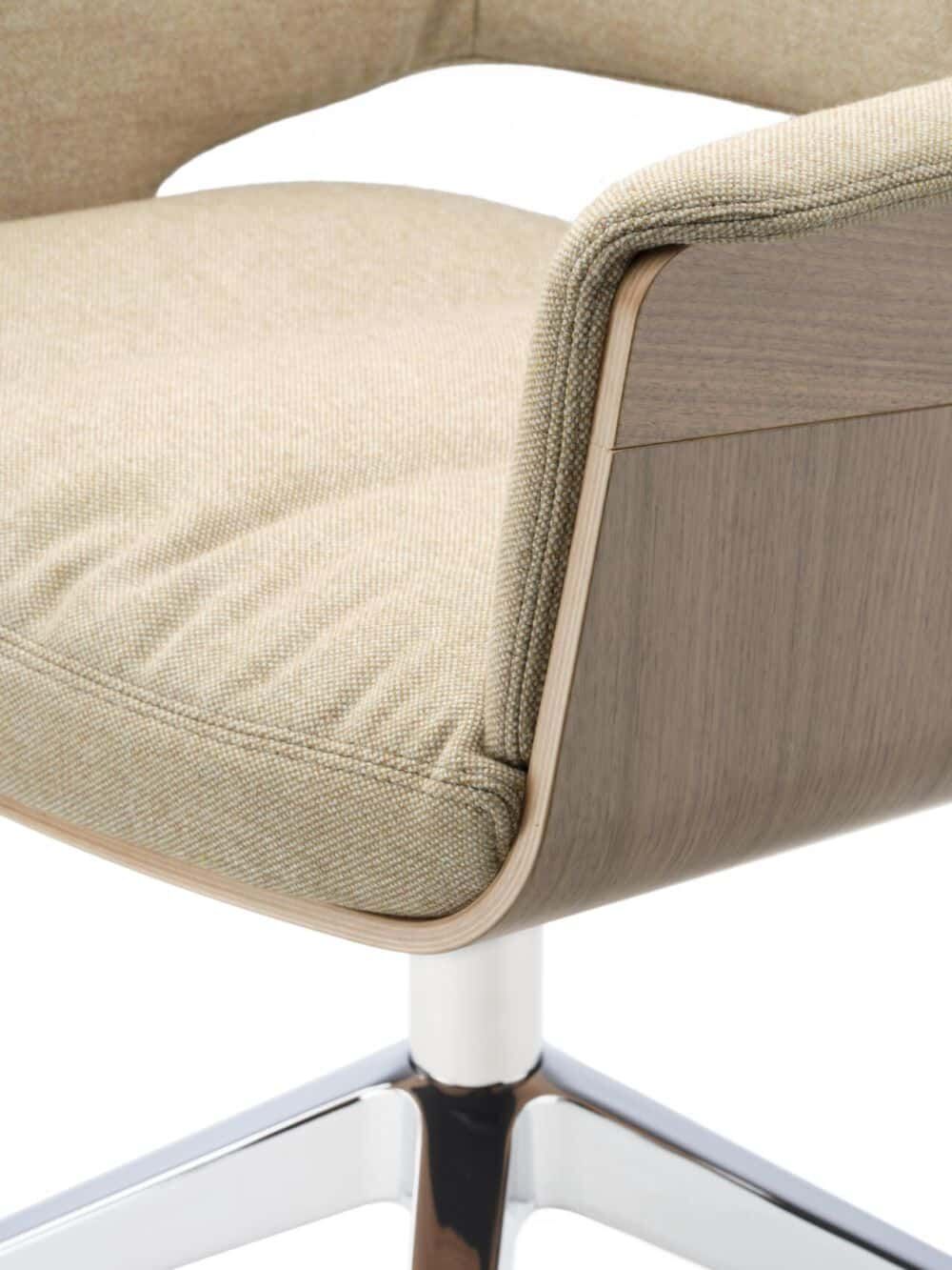 Nahaufnahme eines ergonomischen Stuhls mit gepolstertem Stoff und Holzdetails auf einem Metallfuß.