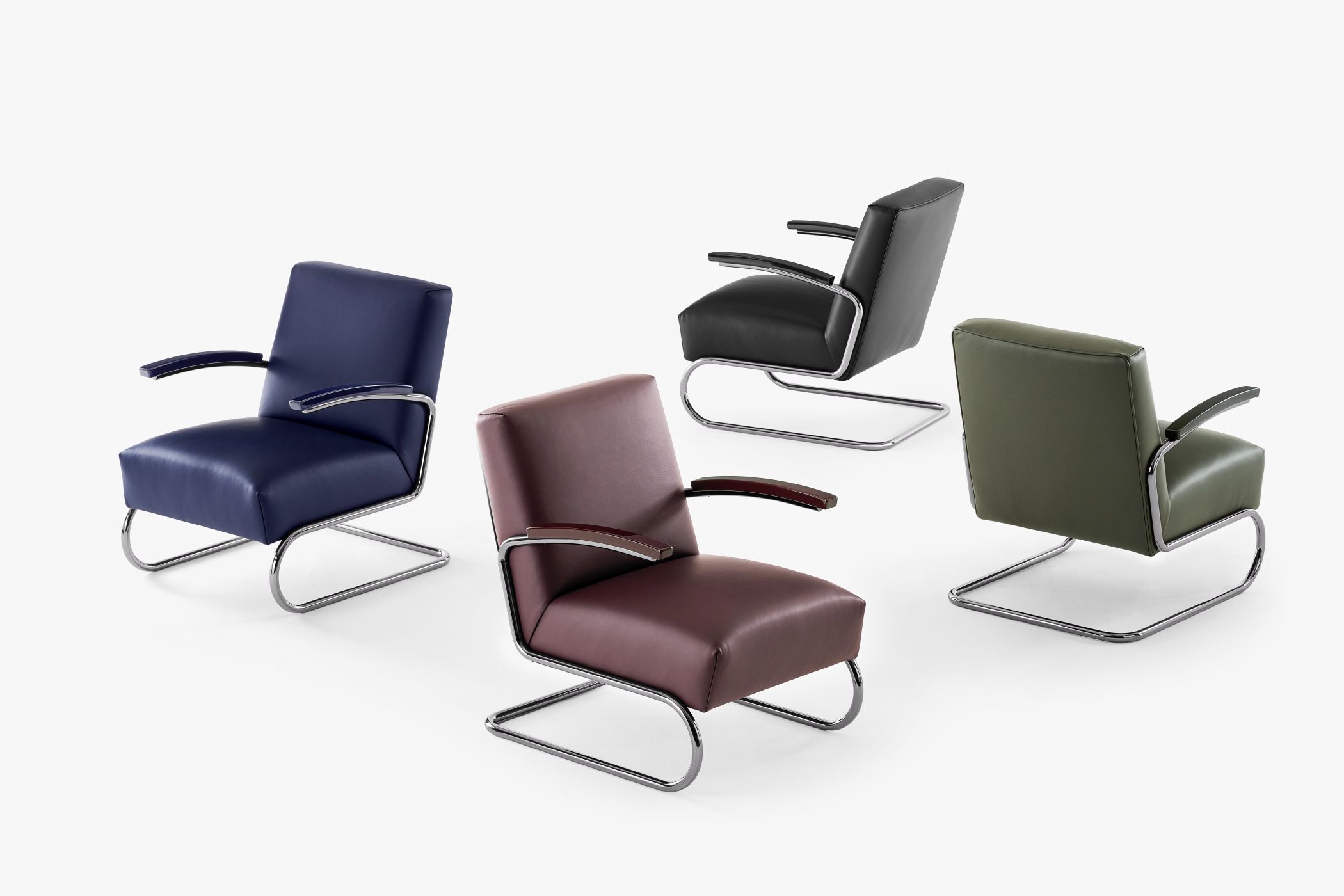 Vier ergonomische Stühle in Blau, Schwarz, Grün und Rotbraun mit Metallgestell auf hellem Hintergrund.