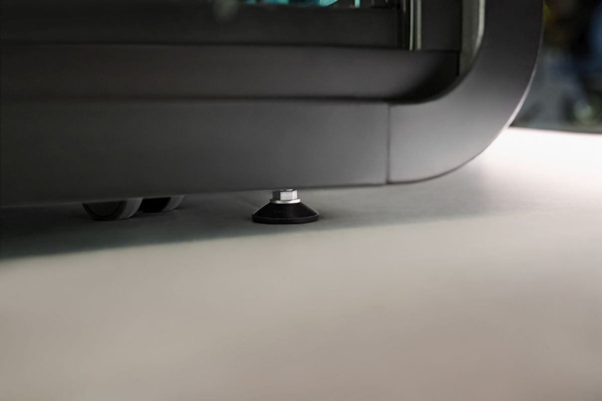 Nahaufnahme eines Stuhlfußes mit Nivellierungselement, zeigt Stabilität und ergonomisches Design auf glattem Boden.