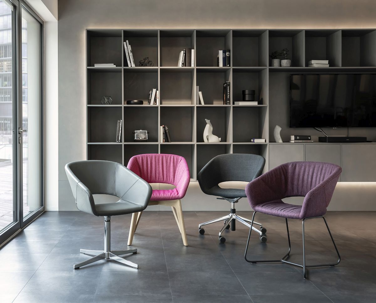 Vier ergonomische Bürostühle in modernem Raum mit Regal im Hintergrund, verschiedene Farben und Designs.
