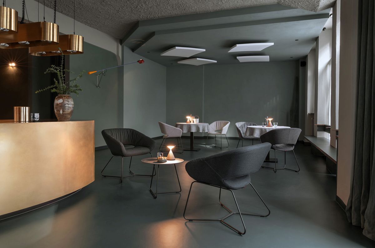 Modern eingerichteter Raum mit ergonomischen Stühlen und Tischen, gedämpfte Beleuchtung und minimalistisches Design.