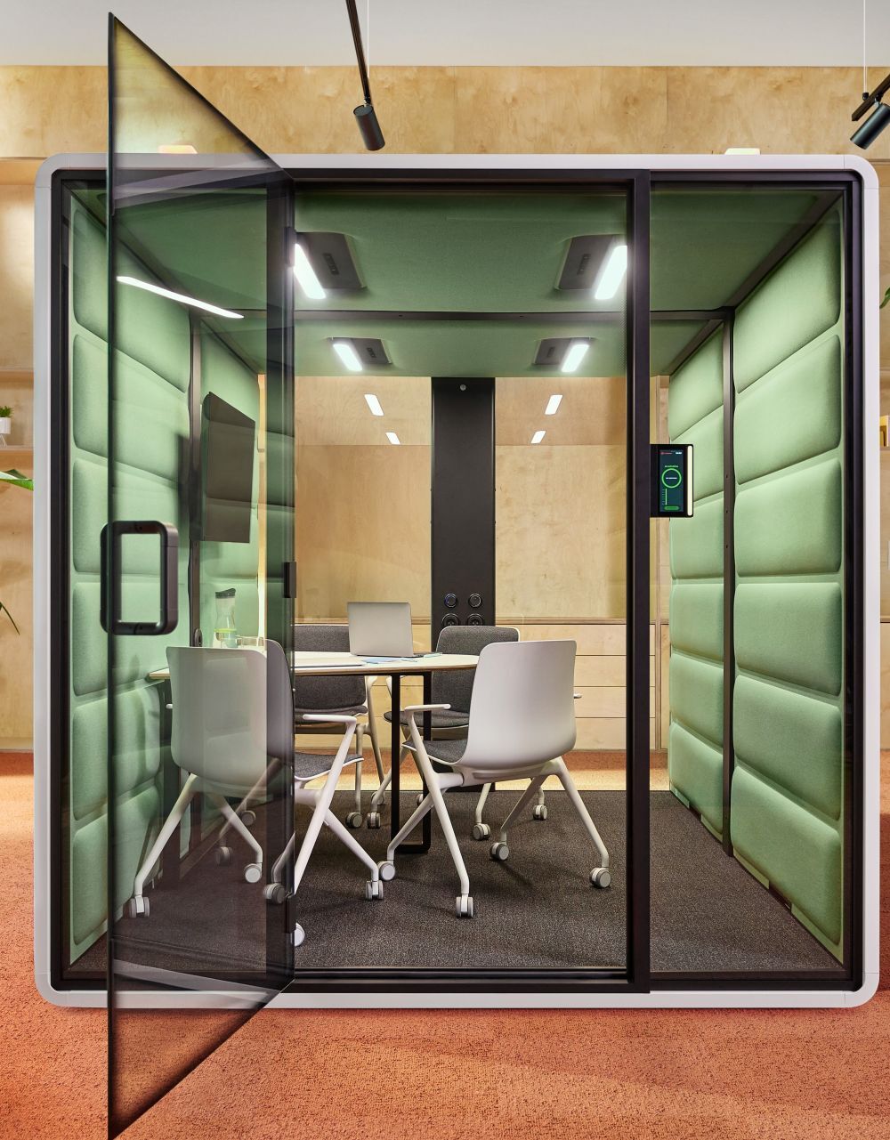 Moderner Büro-Pod mit Glaswand, Tisch und vier ergonomischen Stühlen für konzentrierte Arbeitsumgebung.