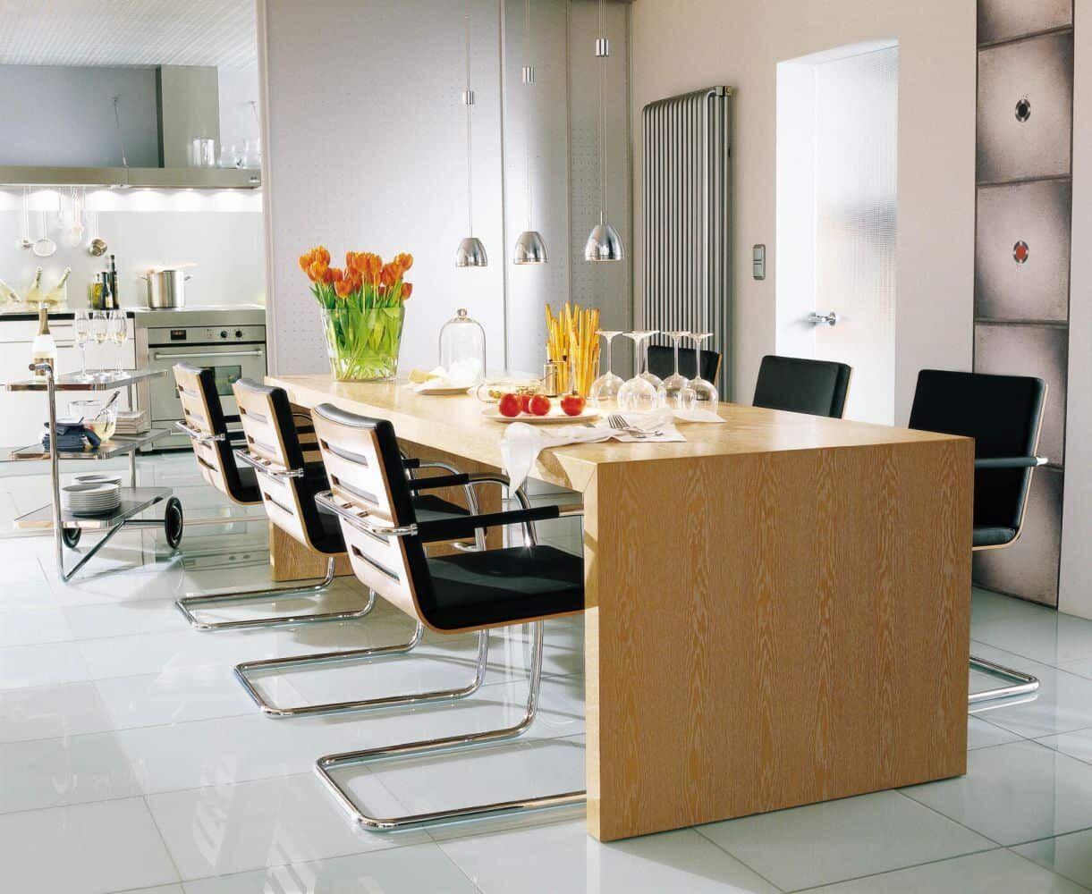 Moderner Essbereich mit ergonomischen Stühlen und großem Holztisch, dekoriert mit Tulpen und Geschirr.