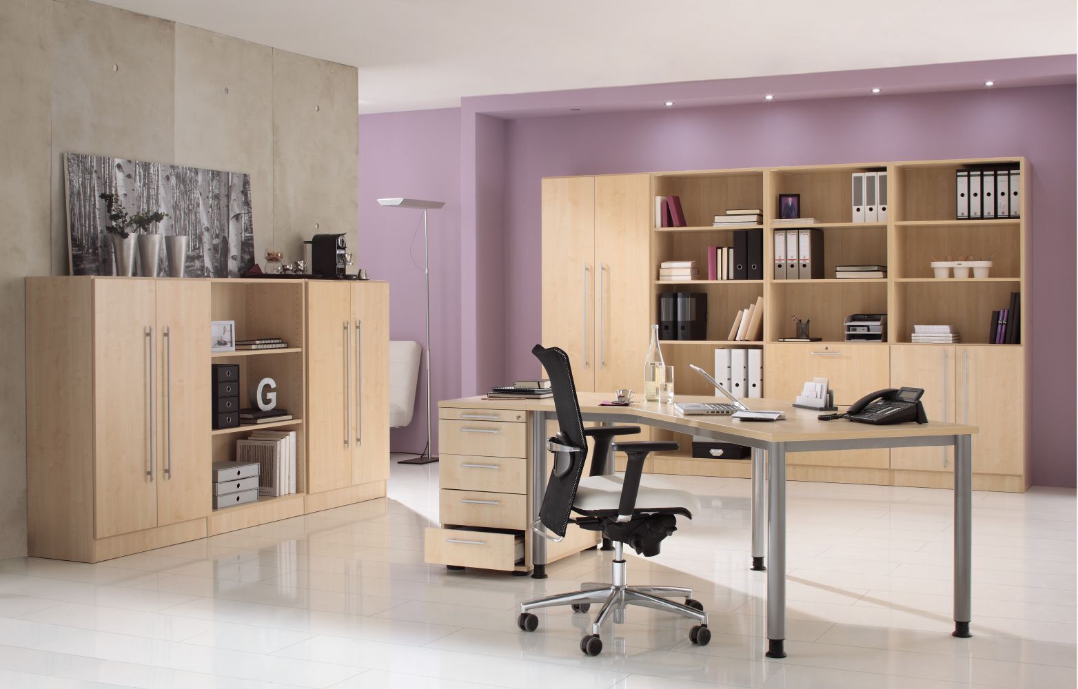 Modernes Büro mit ergonomischem Stuhl, Schreibtisch und hölzernen Regalen an einer lila Wand.