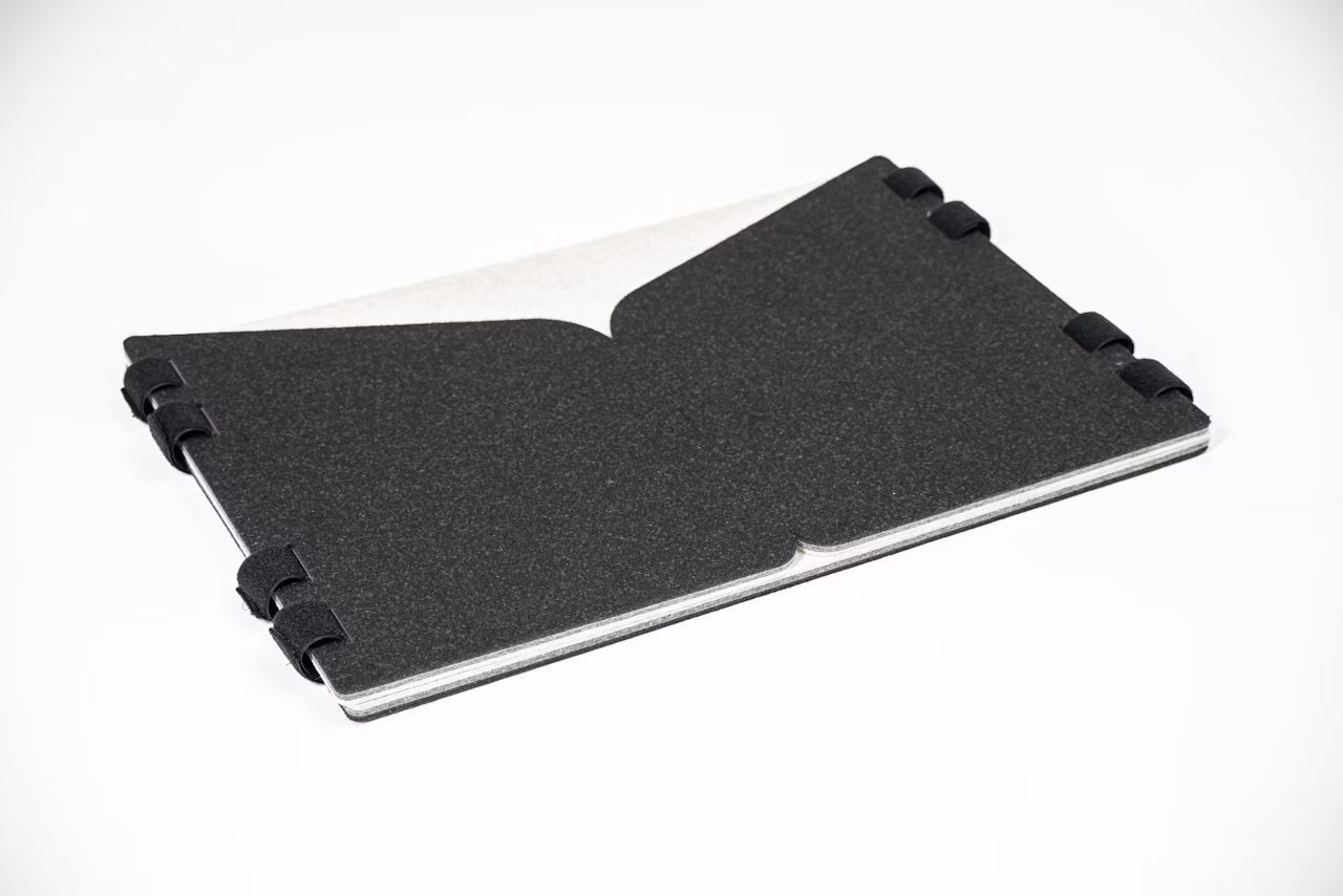 Ergonomische Rückenstütze aus schwarzem Material mit flexiblen Gelenken für dynamisches Sitzen am Arbeitsplatz.