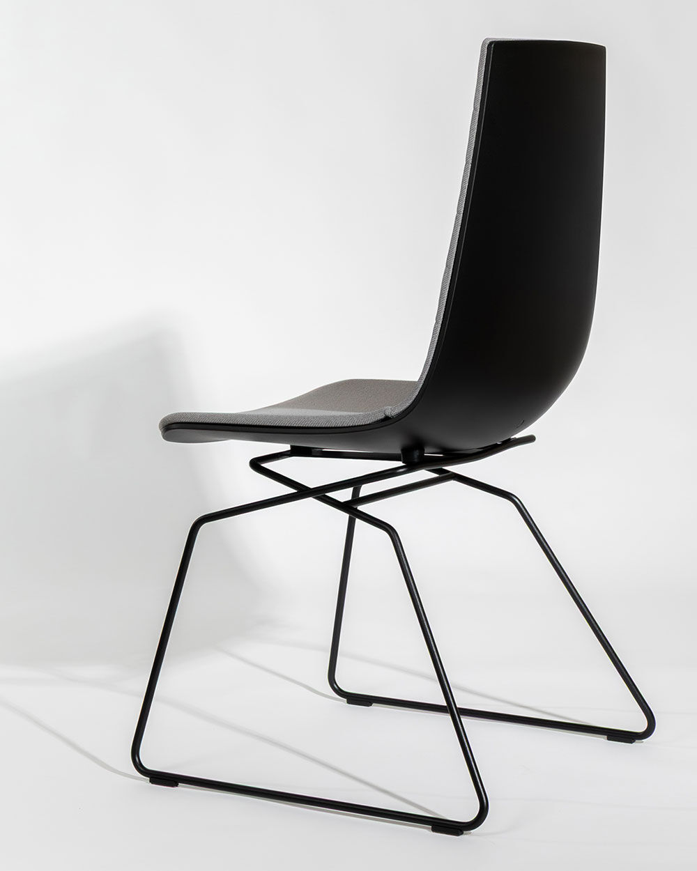 Moderner ergonomischer Stuhl mit minimalistischem Design und schwarzem Metallgestell, geeignet für dynamisches Sitzen.