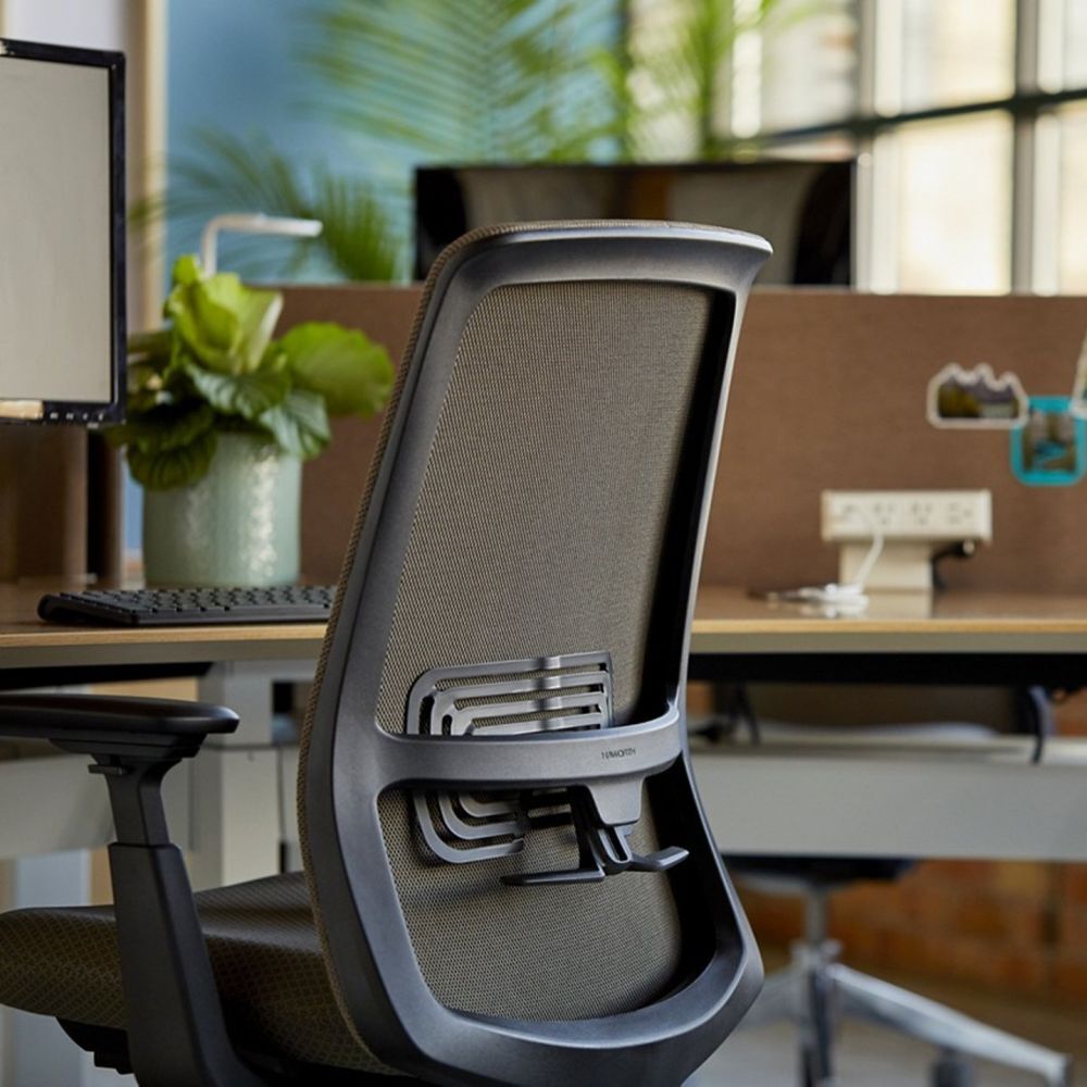 Ergonomischer Bürostuhl mit Netzrückenlehne in einem modernen Büro, betont gesundes und dynamisches Sitzen.