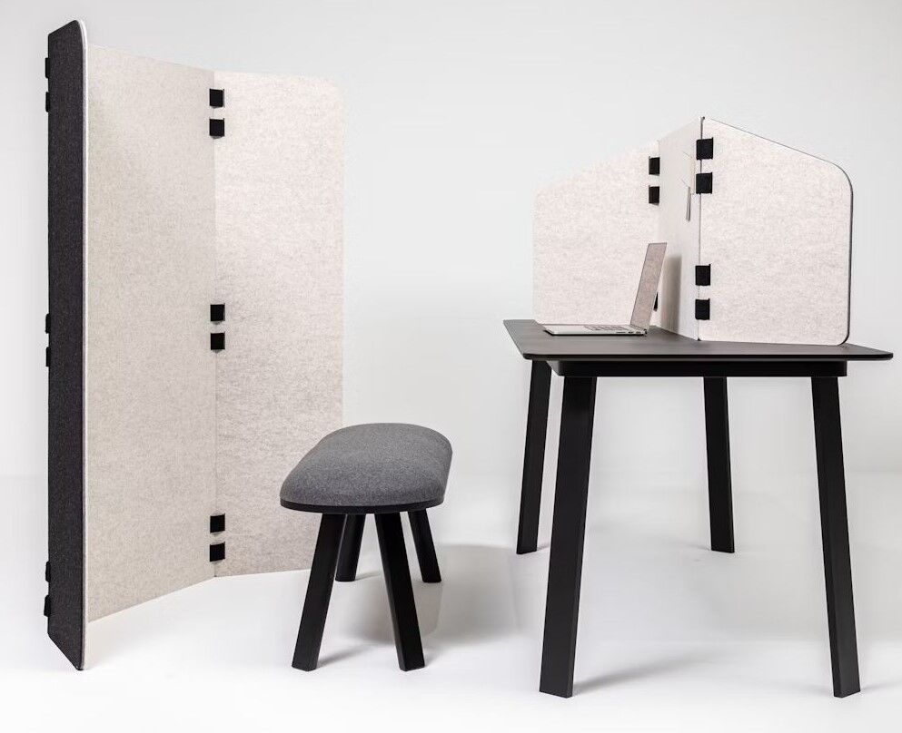 Moderne Büromöbel mit ergonomischem Hocker, Filz-Trennwänden und einem Schreibtisch mit Laptop, ideal für konzentriertes Arbeiten.