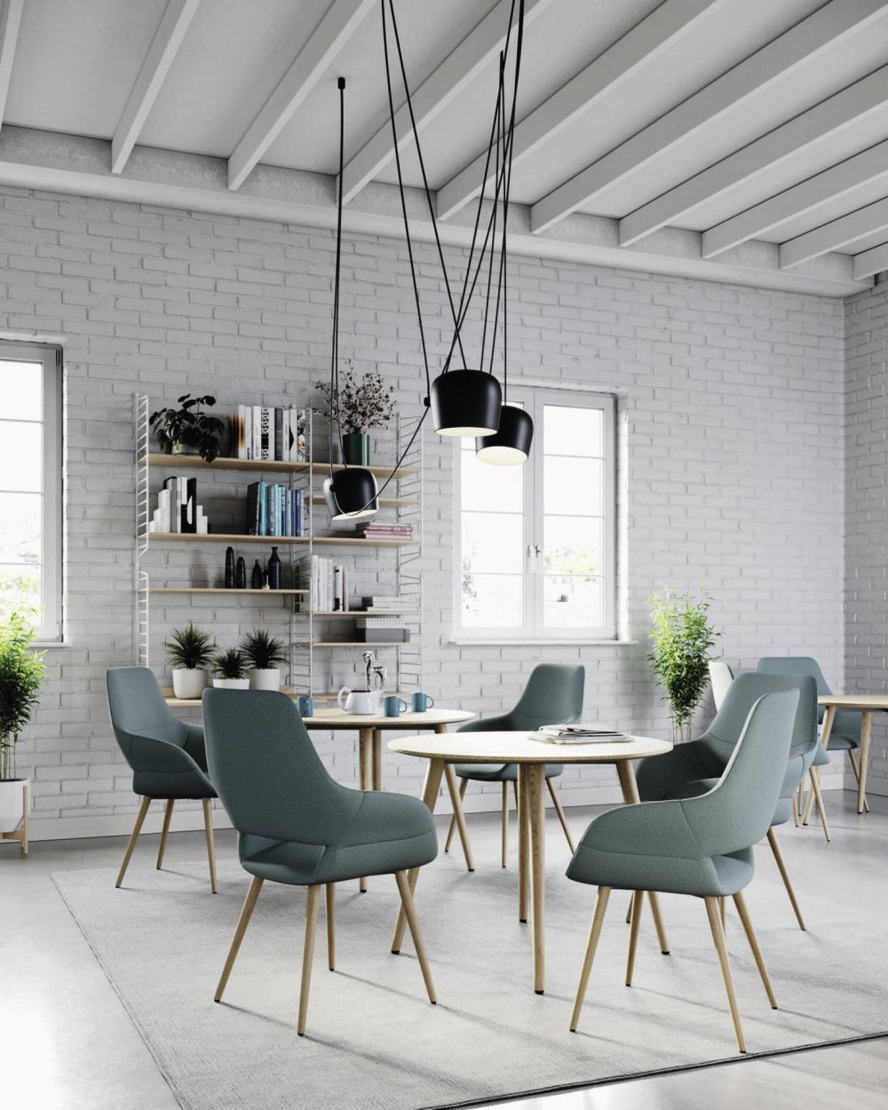 Modernes Büro mit ergonomischen Stühlen und Tischen, dekoriert mit Pflanzen und Regalen vor weißen Backsteinwänden.